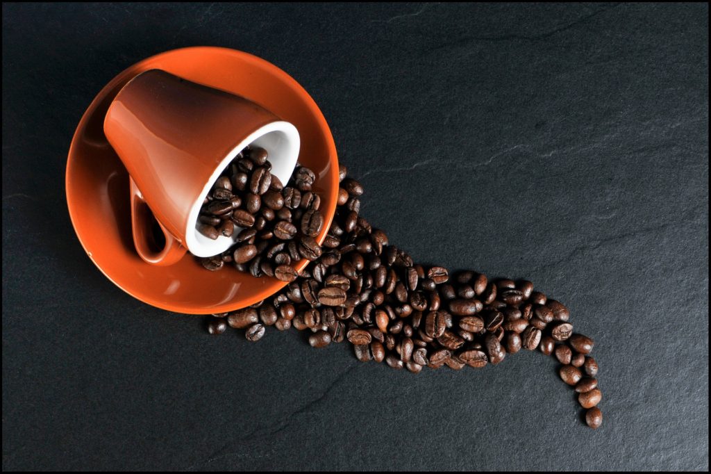 マグカップから流れ出るコーヒー豆